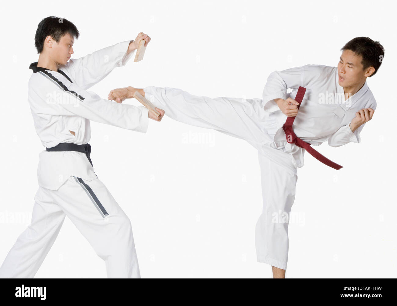 Mid adult man practicing kickboxing with a young man Stock Photo