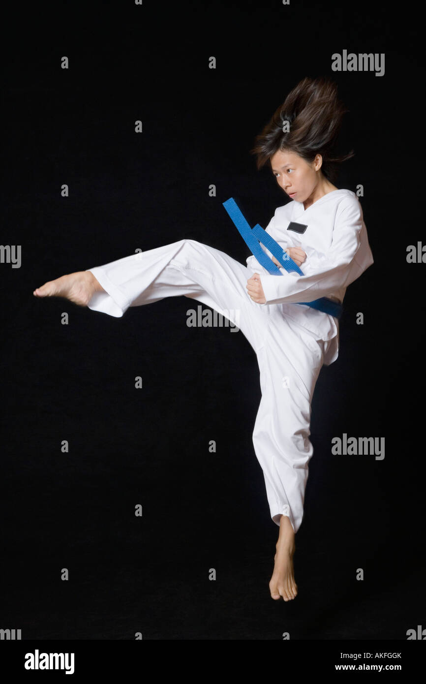 Young woman performing round kick Stock Photo Alamy
