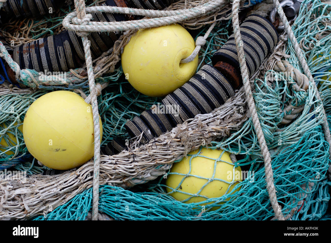 Detail of three yellow flotation buoys and commercial fishing nets Stock Photo