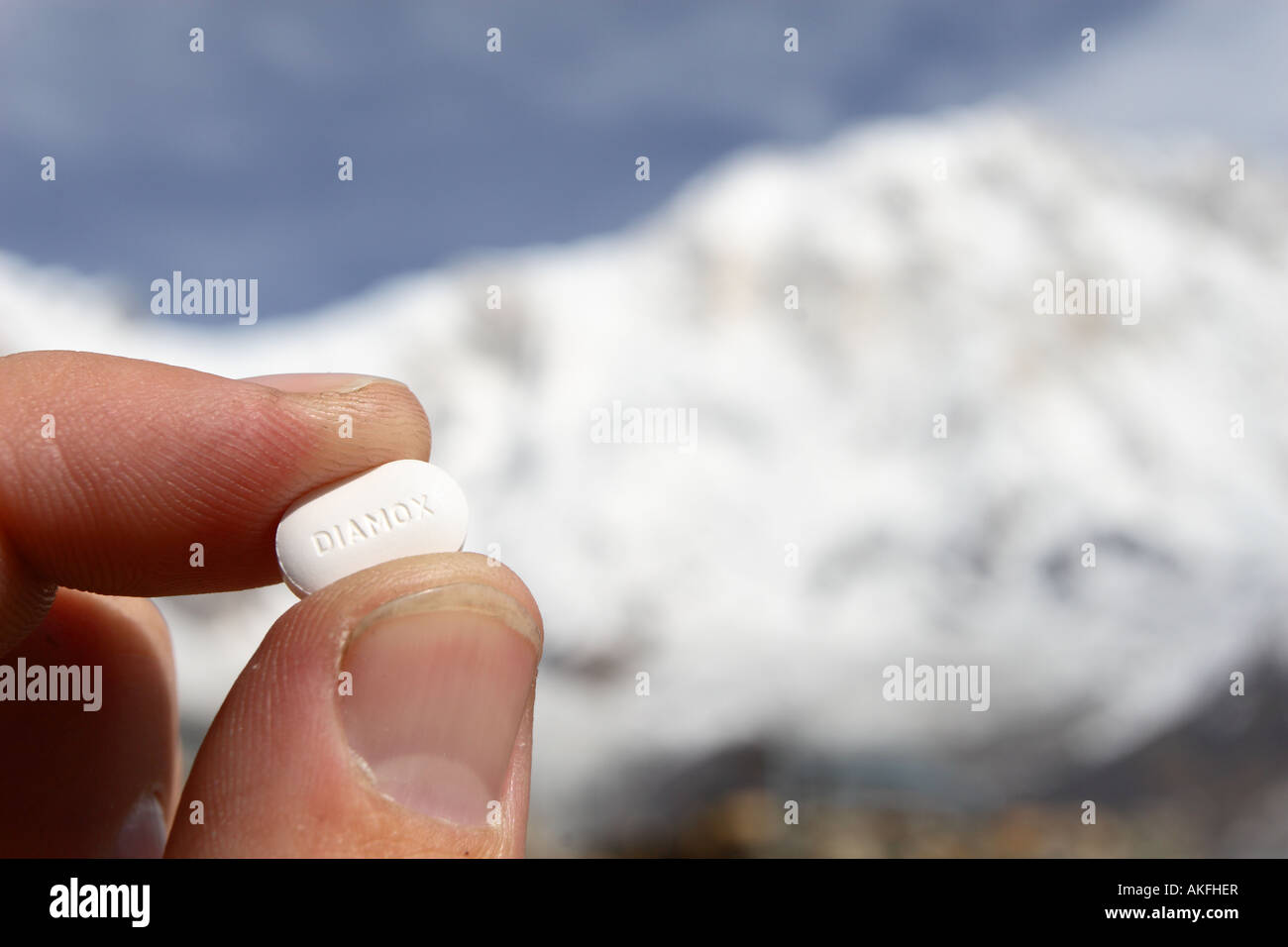 A hiker holds a Diamox altitude sickness pill whilst in the Annapurna mountains of Nepal on hike around the Annapurna circuit and Annapurna base camp Stock Photo