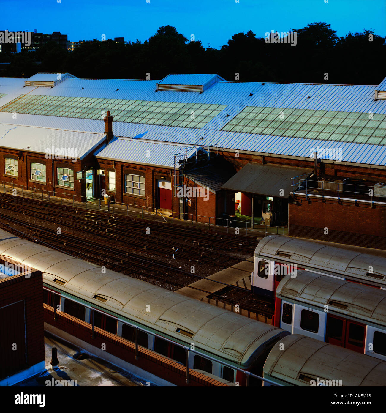 dusk shot overlooking Hammersmith Tube Depot west London inc tube trains offices trees and skyline Stock Photo