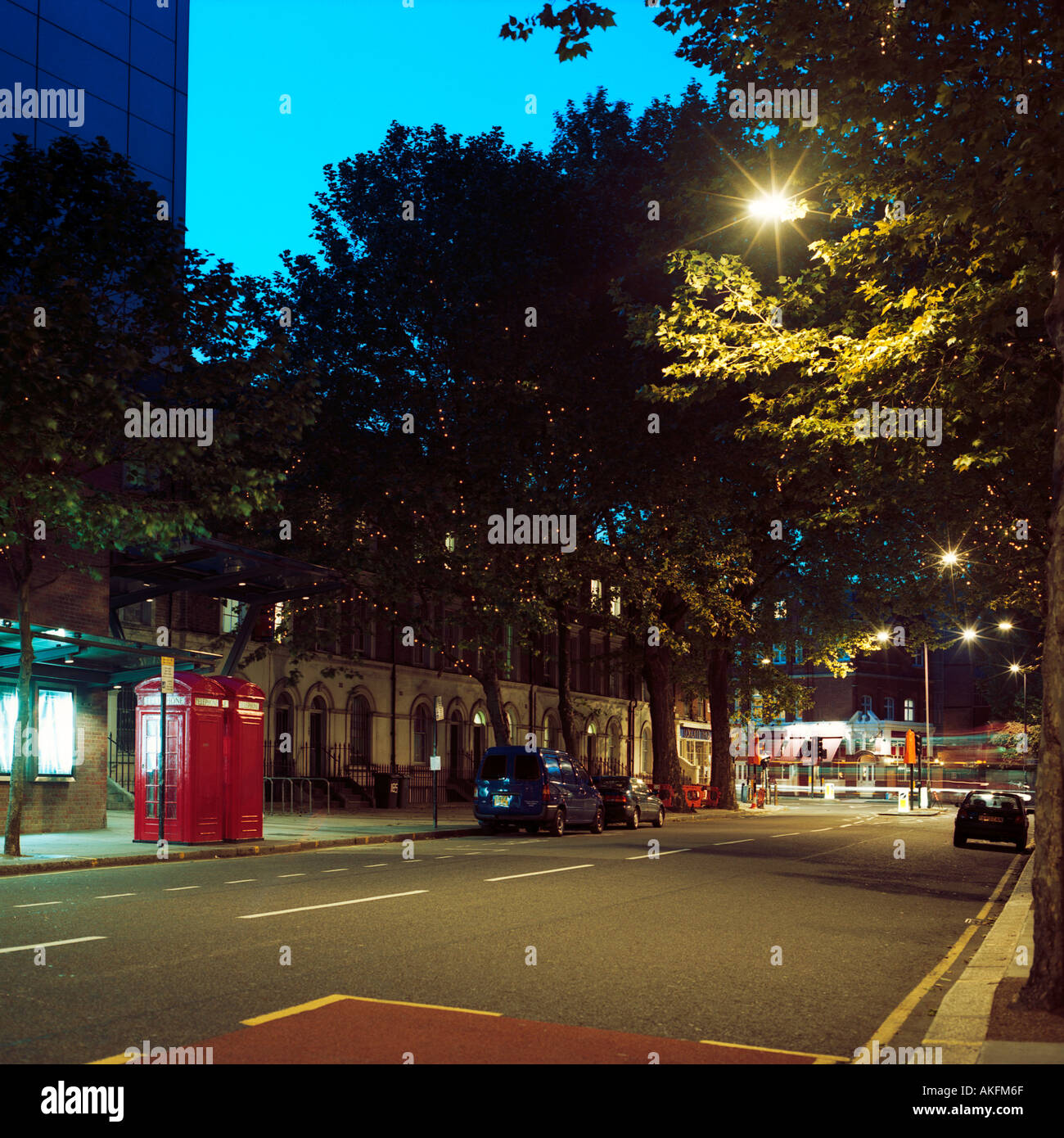 dusk shot of street north London inc red telephone boxes trees cars Stock Photo