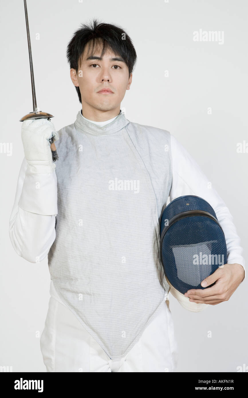 Portrait of a male fencer holding a fencing foil and a fencing mask