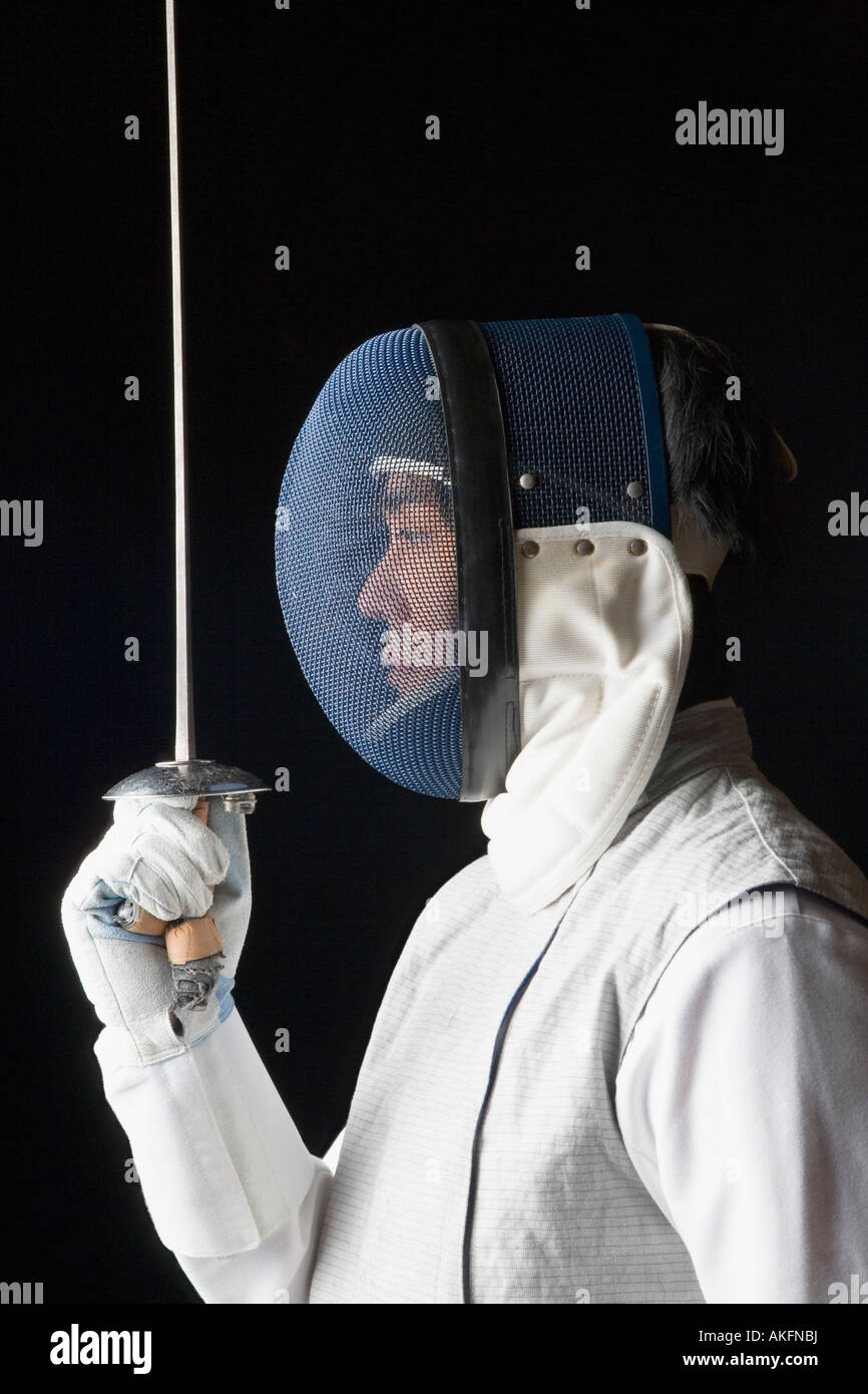 Side profile of a male fencer holding a fencing foil Stock Photo