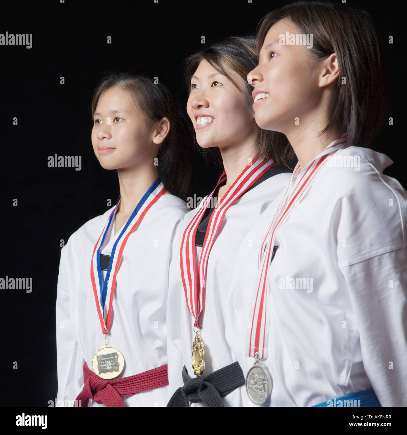 Three young women standing with their medals and smiling Stock Photo