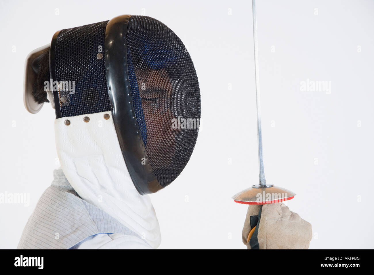Side profile of a fencer wearing a fencing mask and holding a fencing