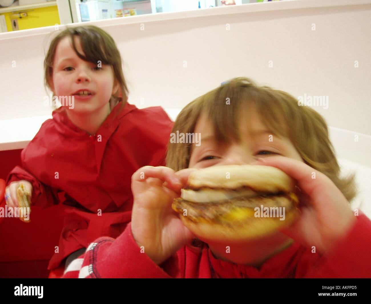 Children eating burgers in a fast food resturant Stock Photo