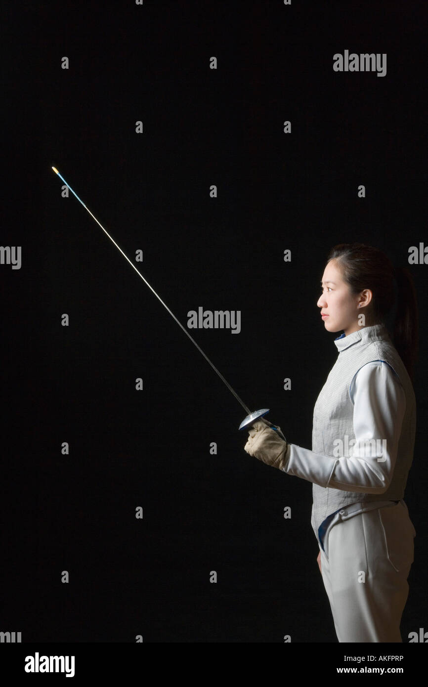 Side profile of a female fencer holding a fencing foil Stock Photo