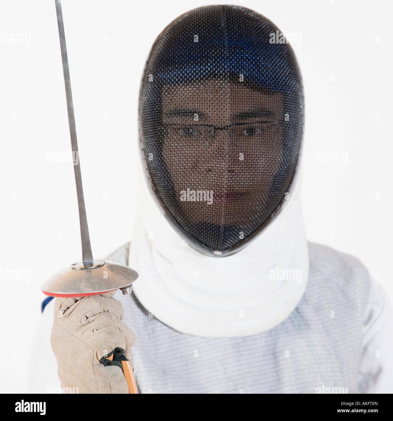 Portrait of a male fencer wearing fencing mask and holding a fencing foil Stock Photo
