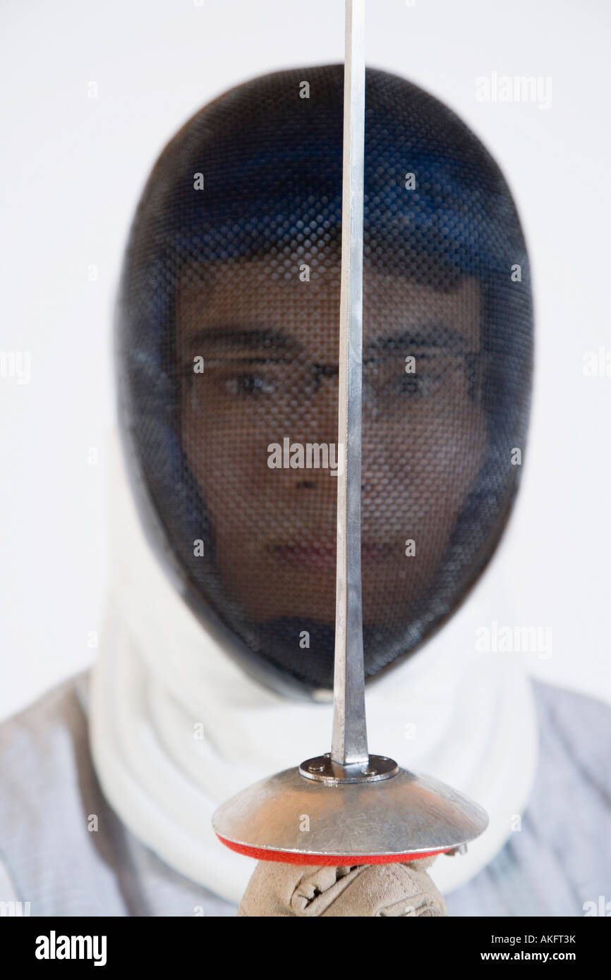 Portrait of a man wearing a fencing mask and holding a fencing foil Stock Photo