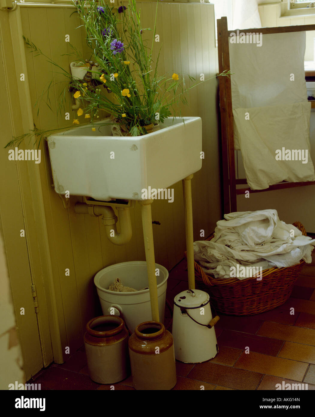 Corner of old fashioned laundry room with white ceramic sink above