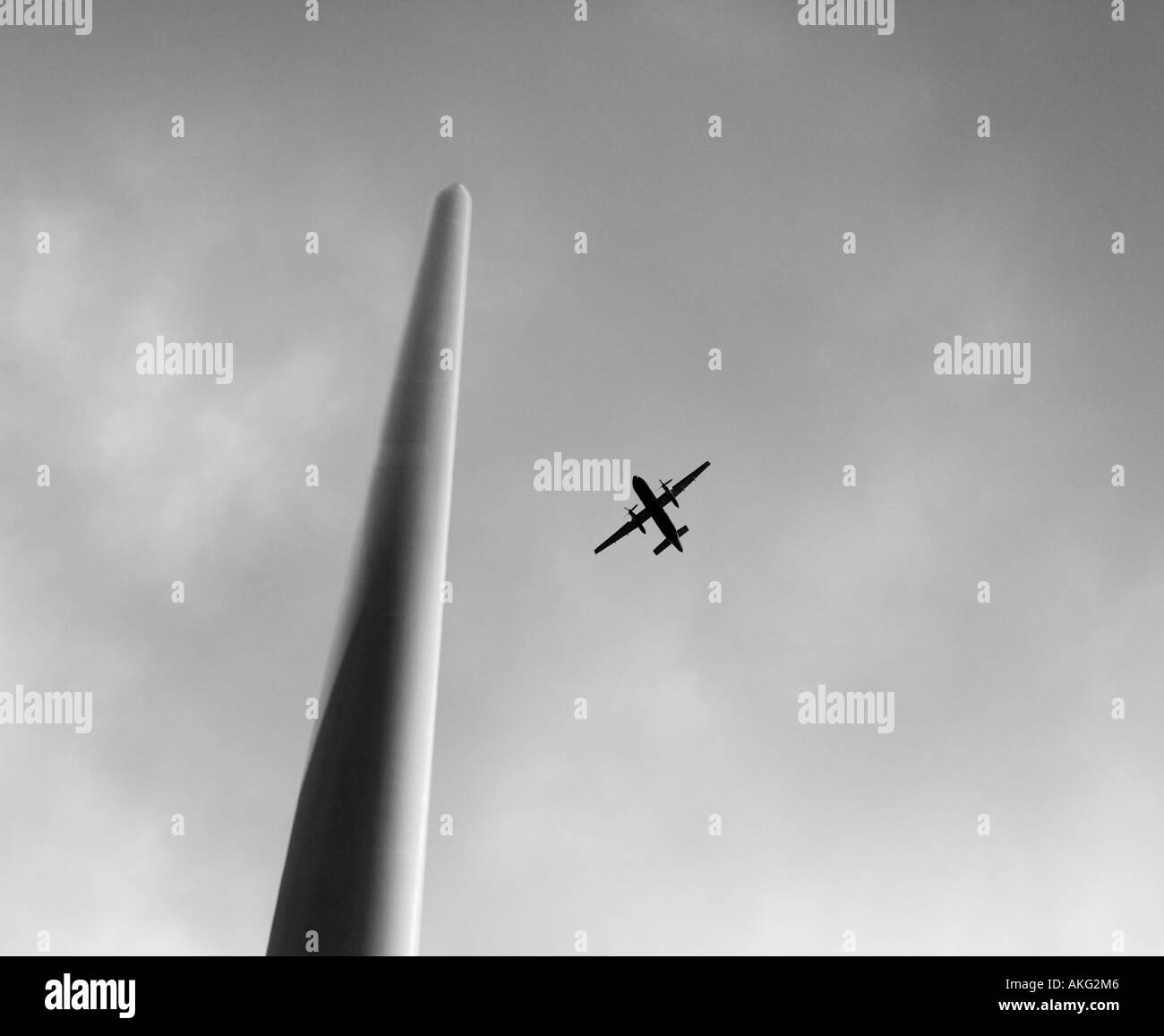 Aircraft flying behind a blade on a wind turbine tower, Scotland Stock Photo