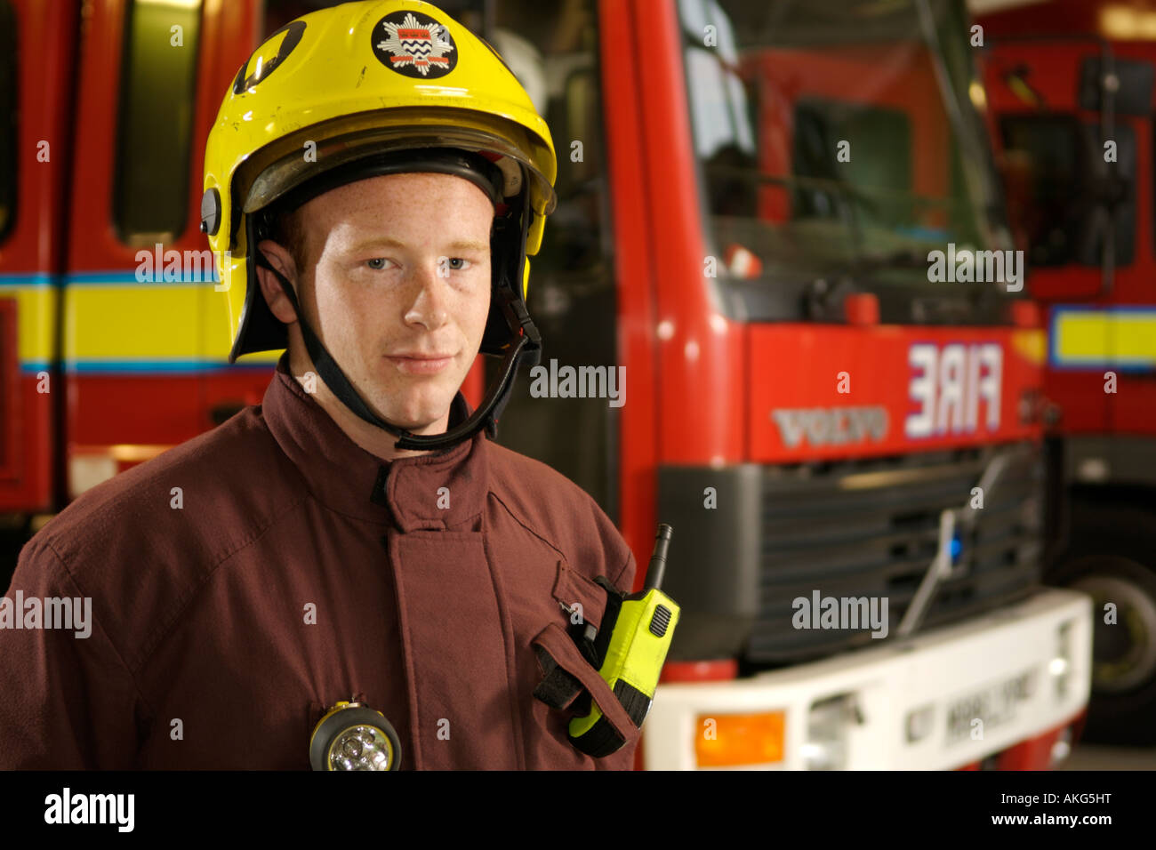 Portrait of London Fire Brigade fireman Dan Savva in front of fire trucks. Stock Photo