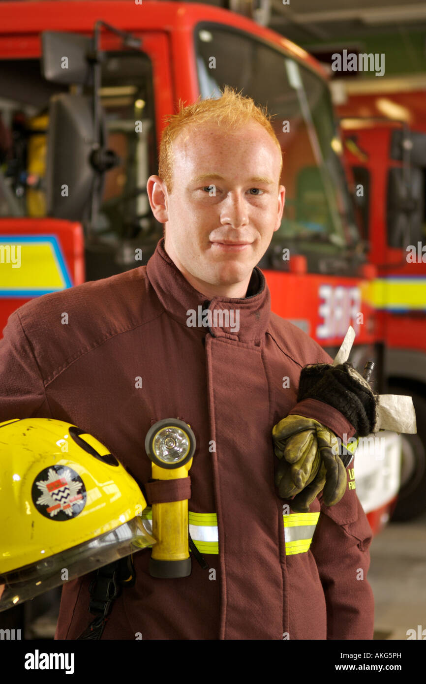 Portrait of London Fire Brigade fireman Dan Savva in front of fire trucks. Stock Photo