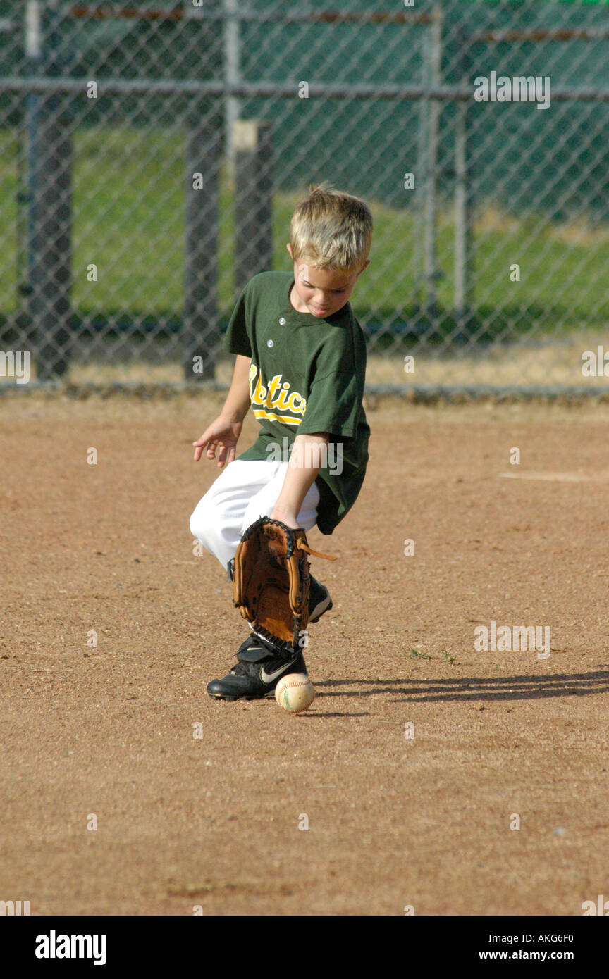 Little League boy working on learning how to catch grounders on