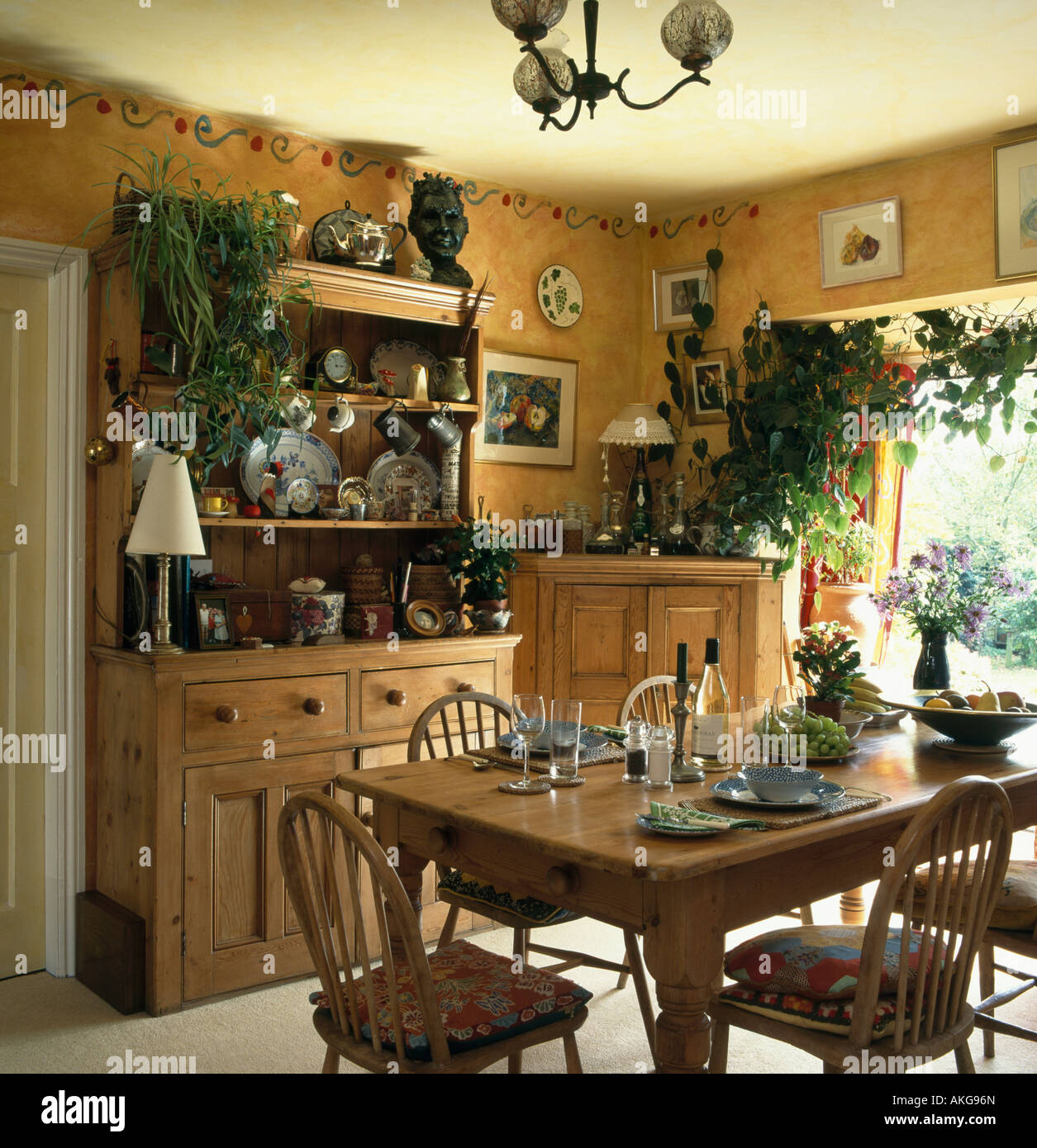 Small pine dresser and dining table in yellow dining room with painted  border on the wall Stock Photo - Alamy