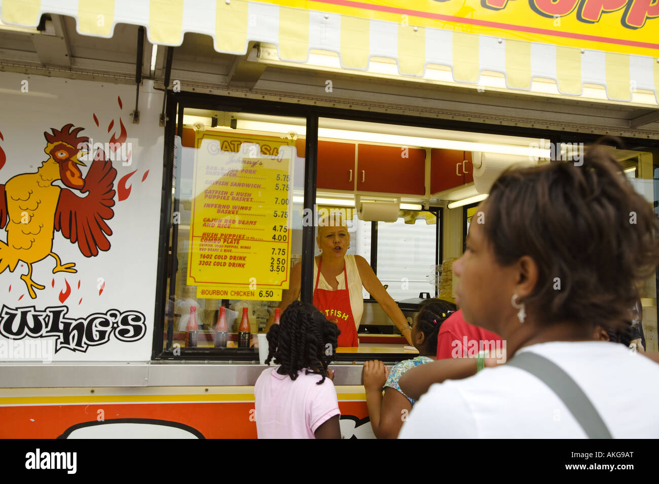 WISCONSIN Milwaukee Customers purchase food at window from female worker Cajun food booth at State Fair Stock Photo