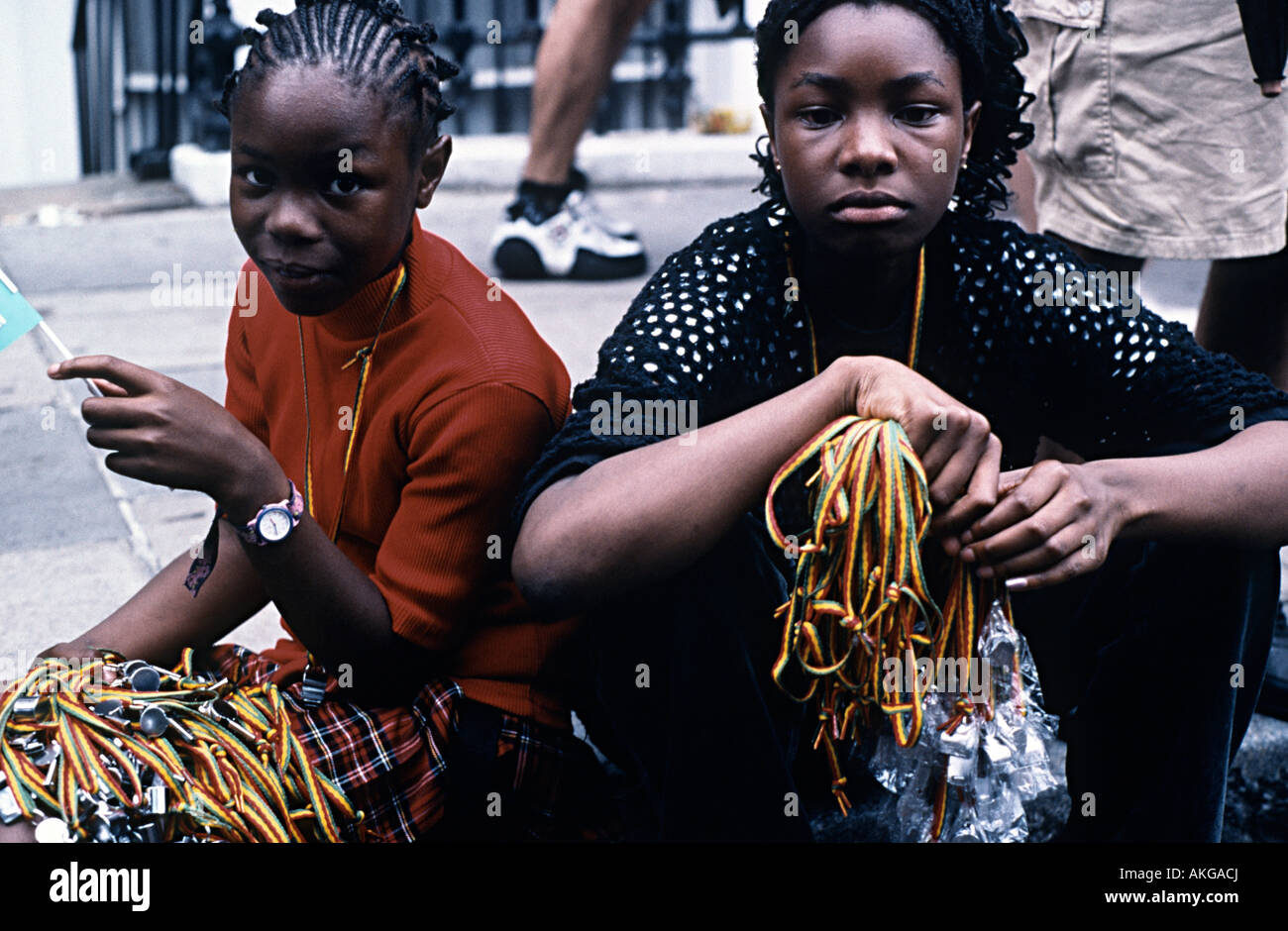 nottinghill carnival two young girls selling whistles in the street Stock Photo