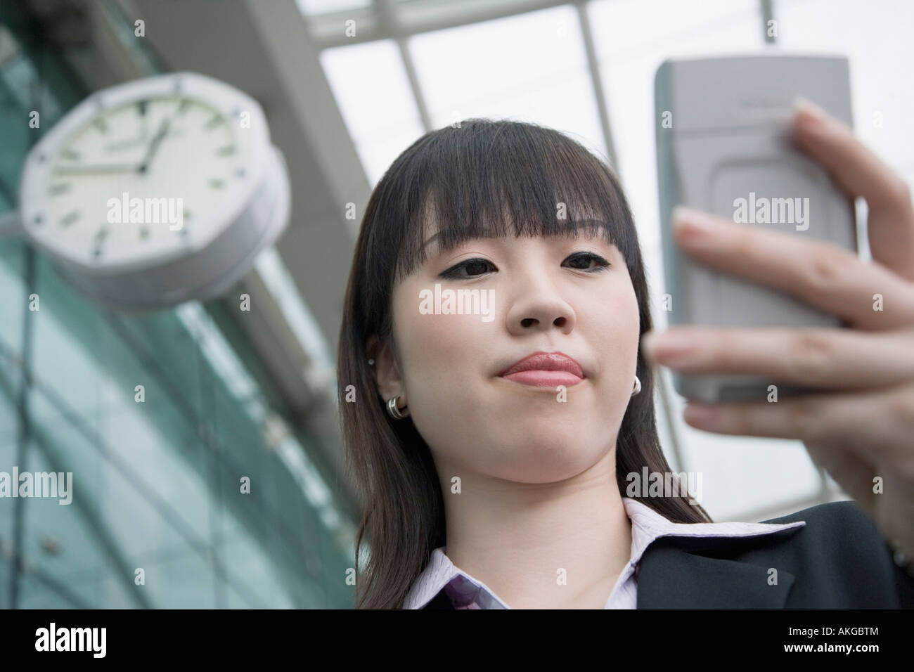 Low angle view of a businesswoman using a palmtop and waiting at an airport lounge Stock Photo