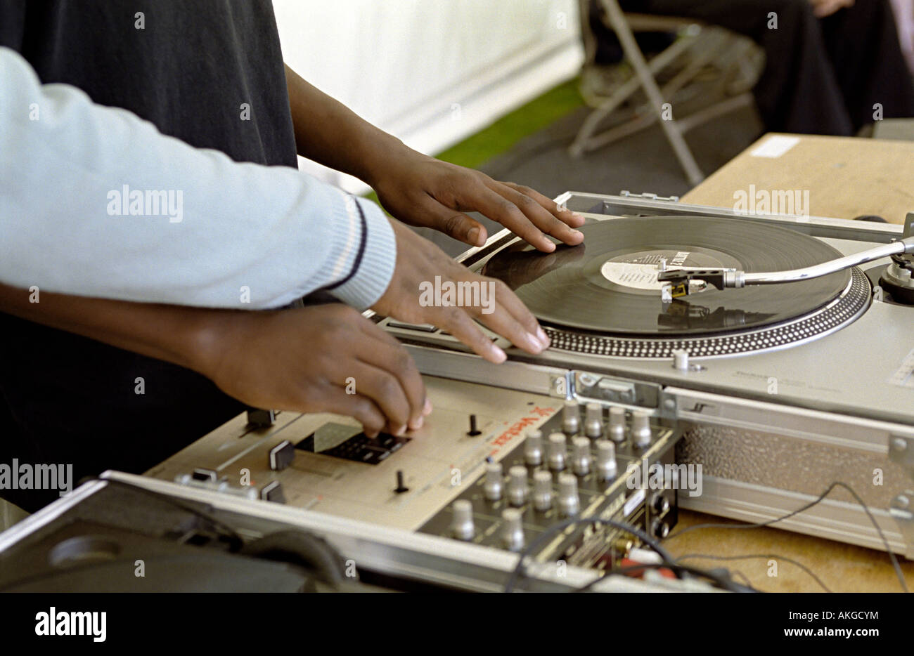 djs playing hip with their hands and scratching with a boy being shown how to dj showing their hands Stock Photo