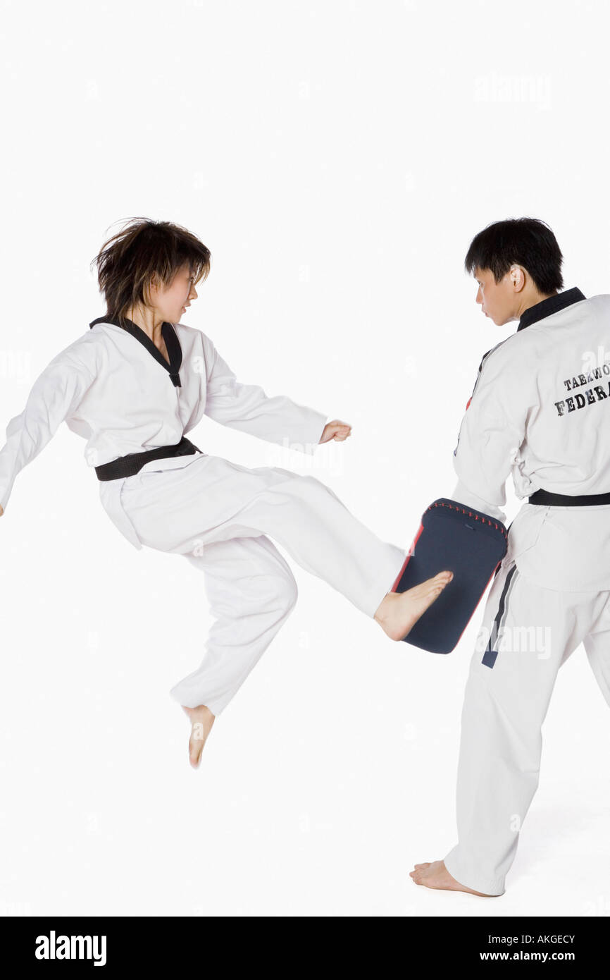 Female karate instructor teaching martial arts to a young man Stock