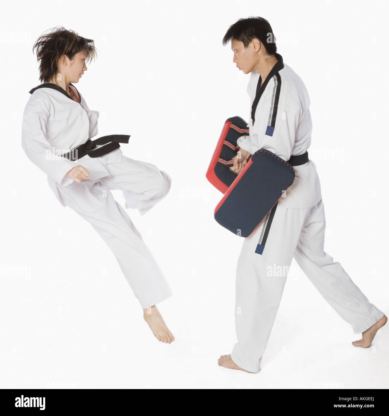 Female karate instructor teaching martial arts to a young man Stock