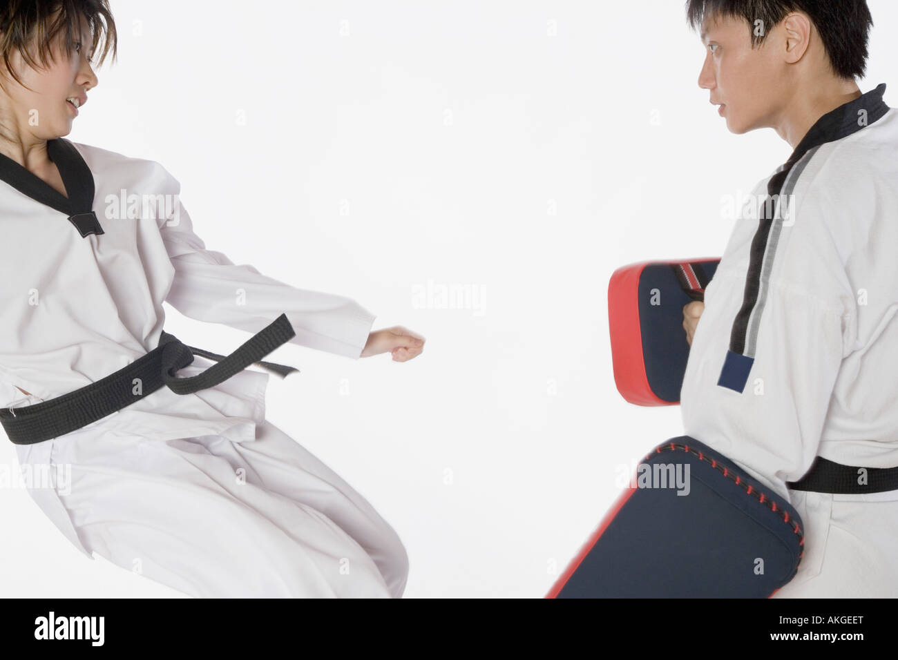 Female karate instructor teaching martial arts to a young man Stock