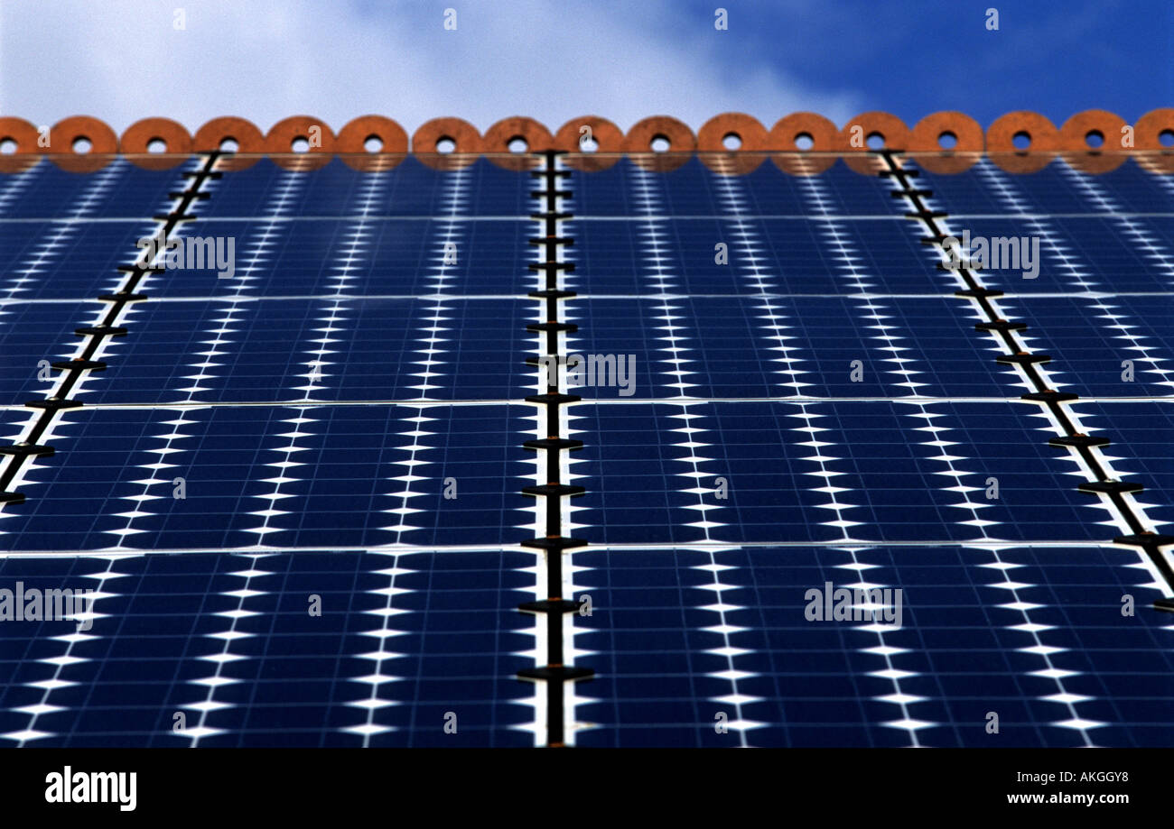 Photovoltaic cells (solar panels) on the roof of a house to produce electricity. Stock Photo