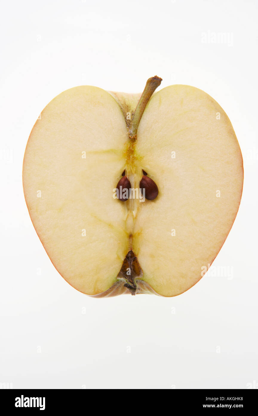 FRESH APPLE SLICED IN HALF SHOWING PIPS ON WHITE BACKGROUND Stock Photo