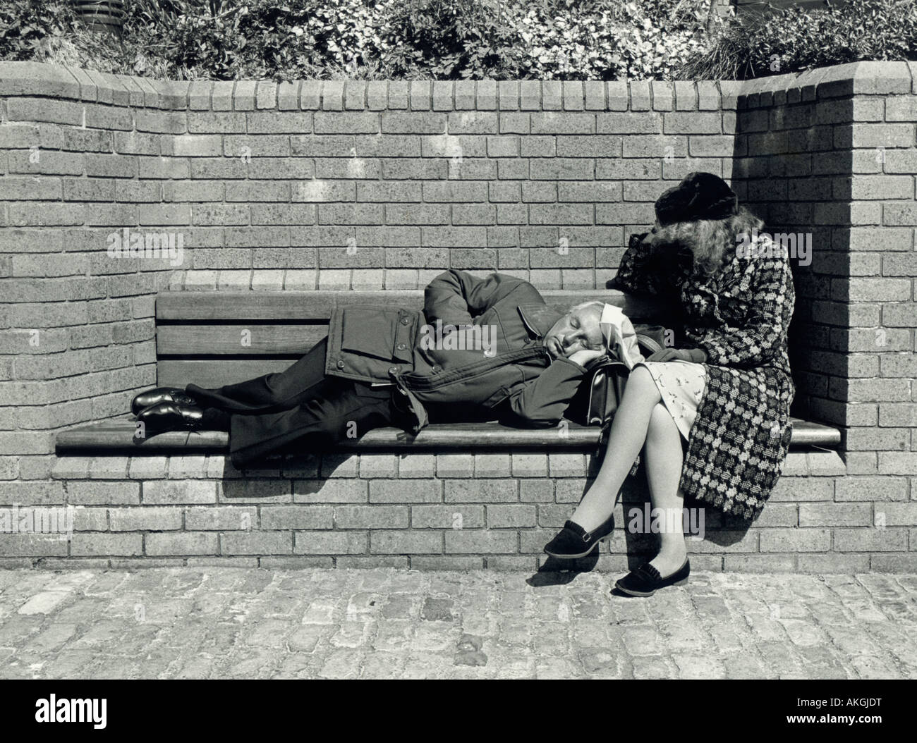 Candid couple sleeping on bench, Bristol, UK. Black & white photo, 1980s. Stock Photo