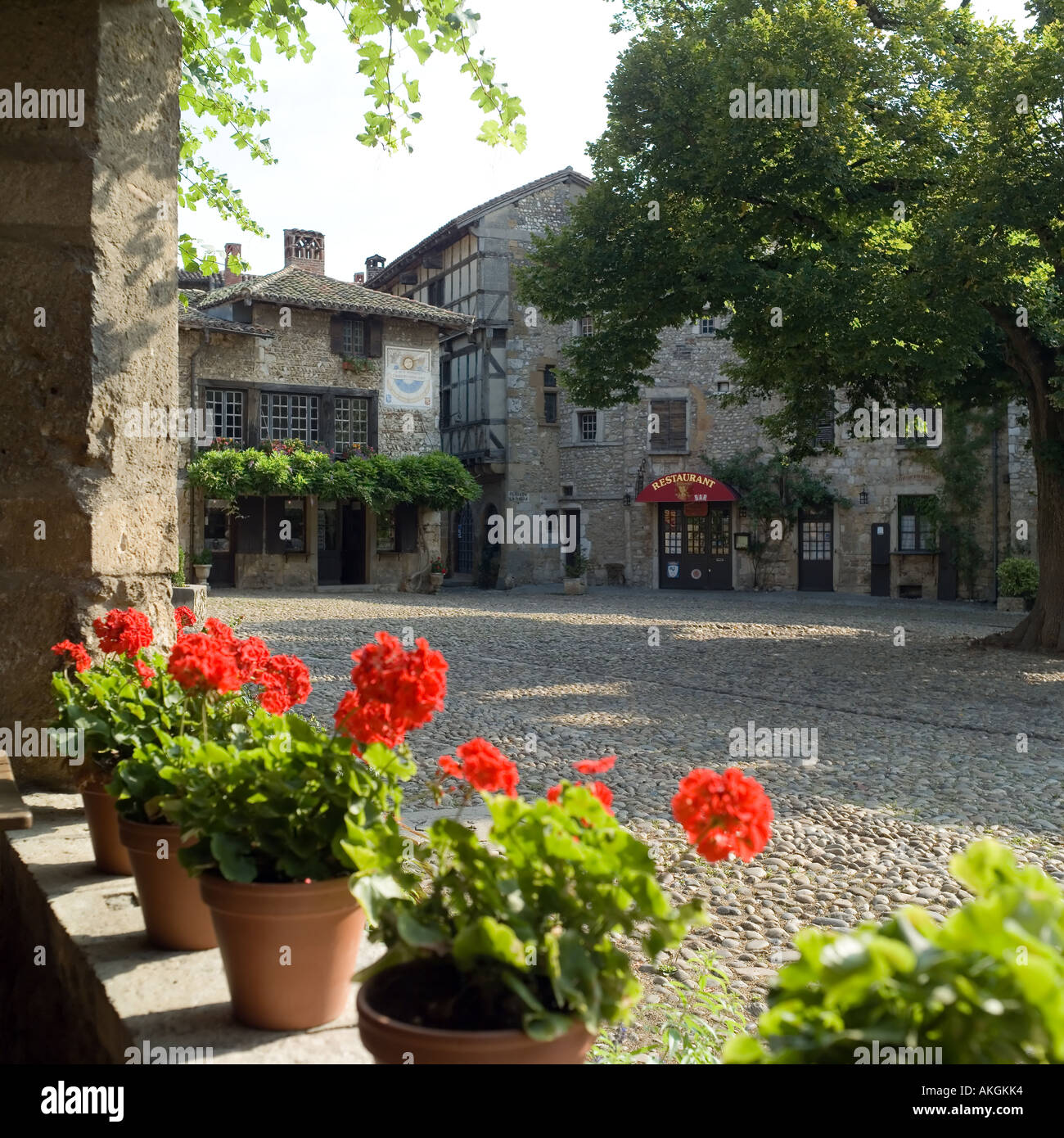 Place de la Halle square, place du Tilleul, red geranium flowers, Pérouges medieval walled city, Ain, Rhône valley, France Stock Photo