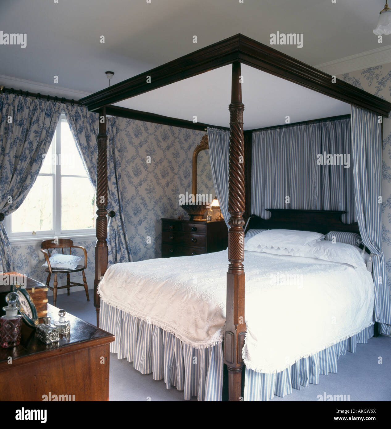 Blue striped curtains and valence on four poster bed in bedroom with