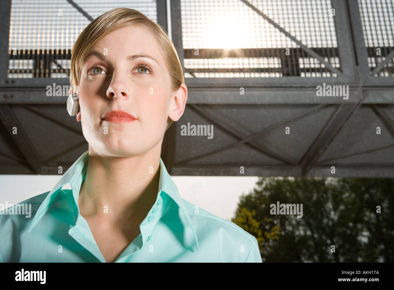 Woman wearing headset standing outdoors Stock Photo
