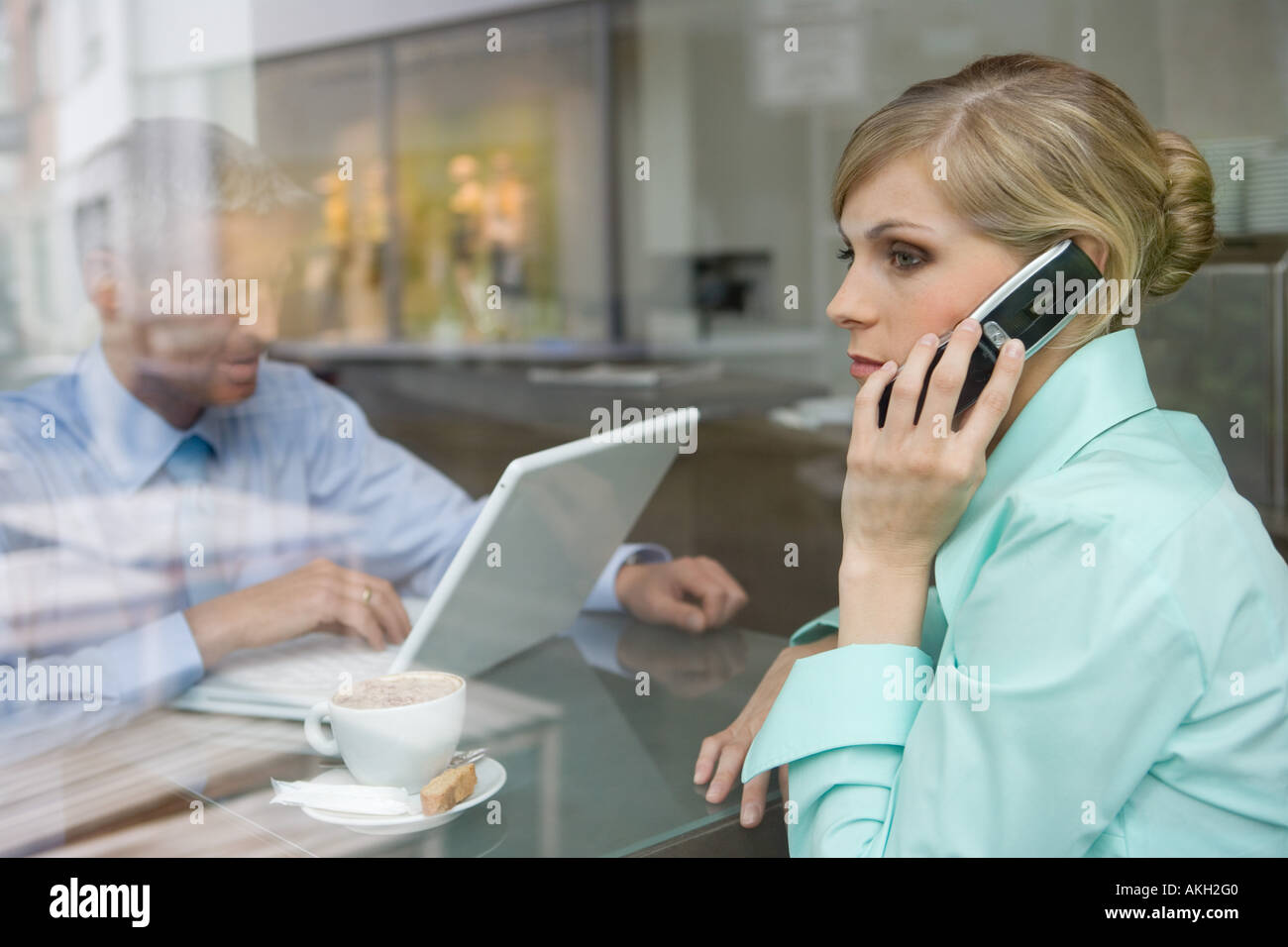 Business couple working at bar table, view through window Stock Photo