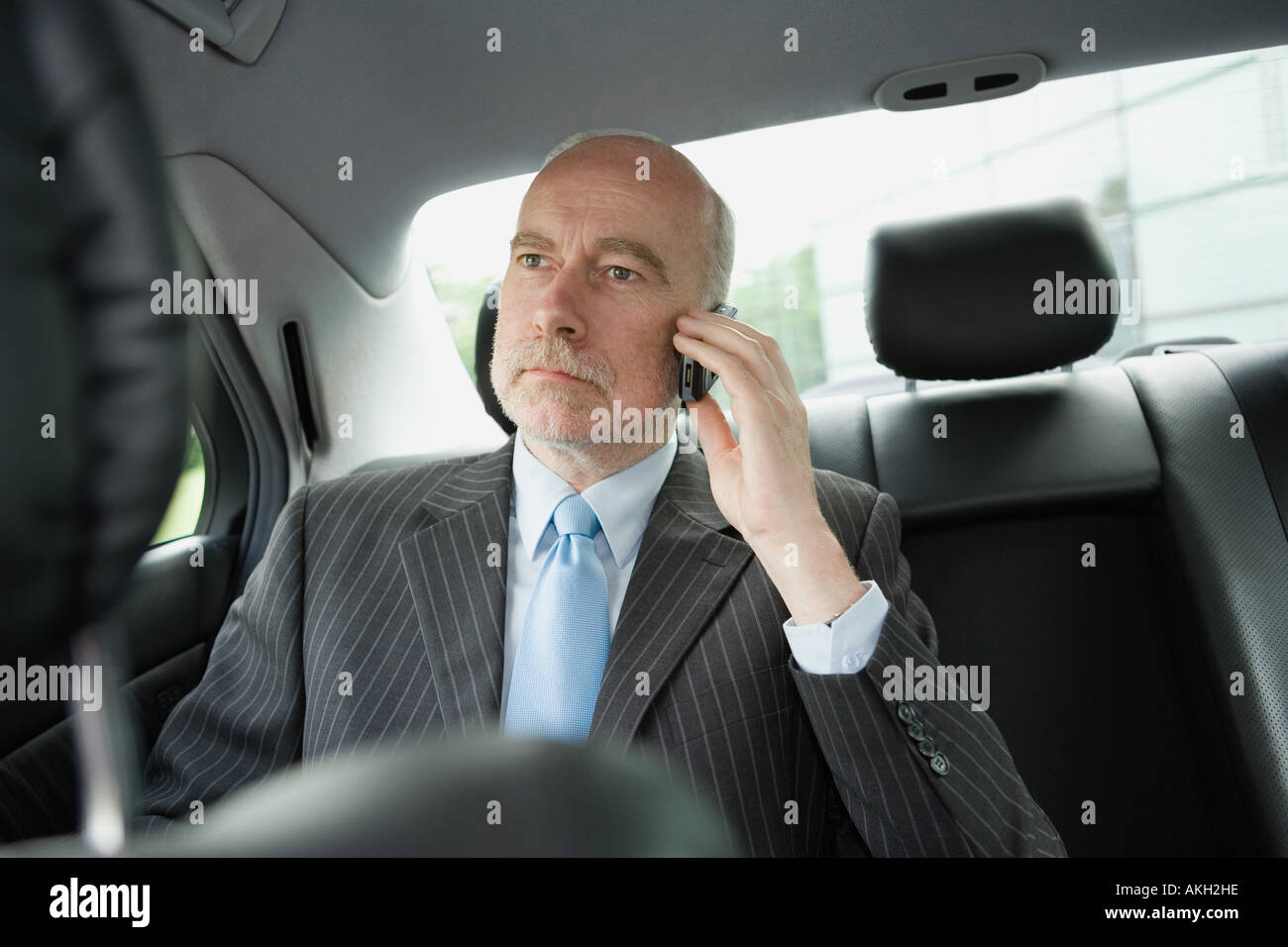 Businessman on phone sitting in car Stock Photo