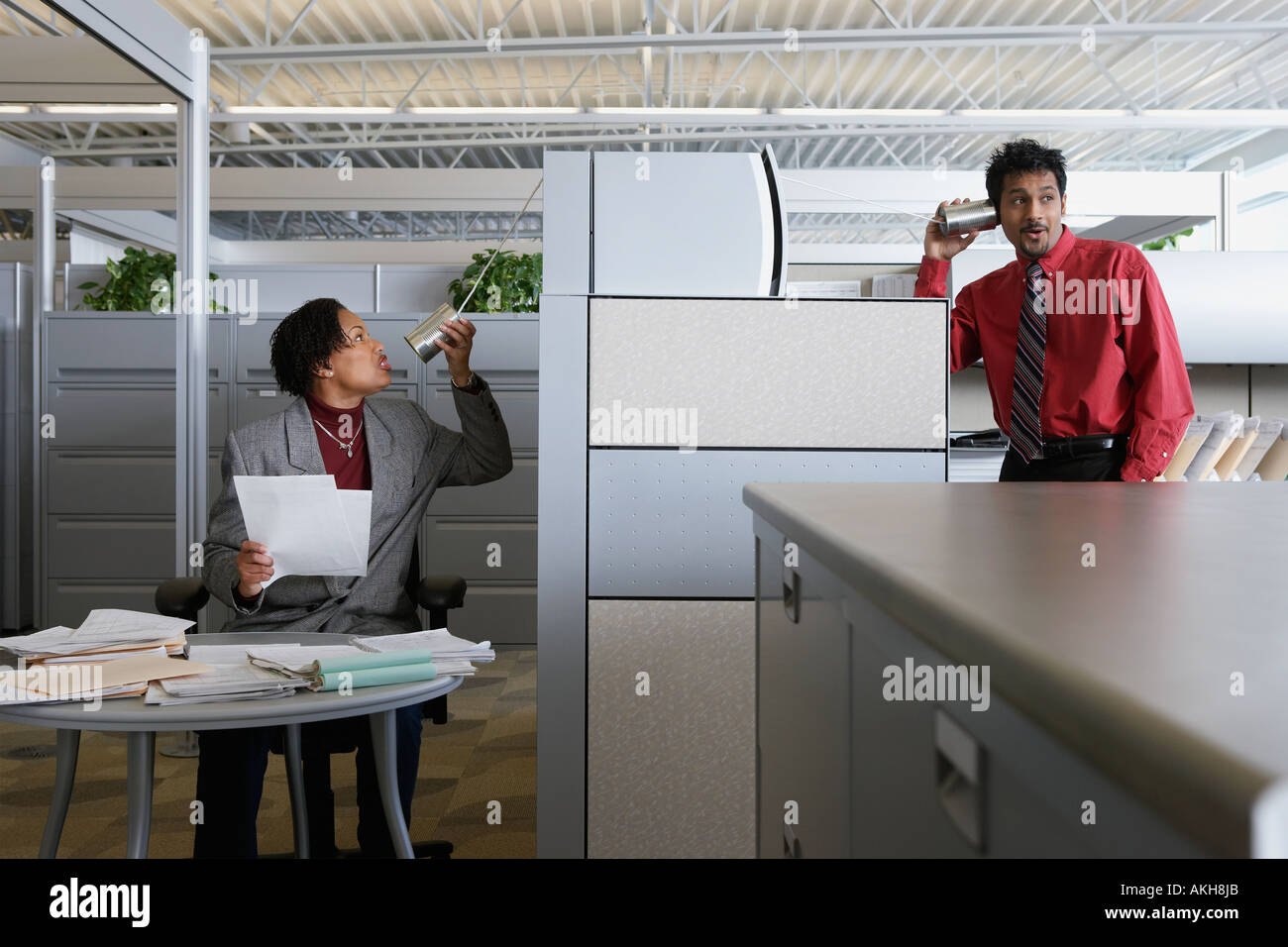 Two office workers using a tin can telephone Stock Photo