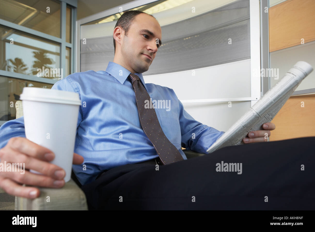 Man reading a broadsheet newspaper Stock Photo