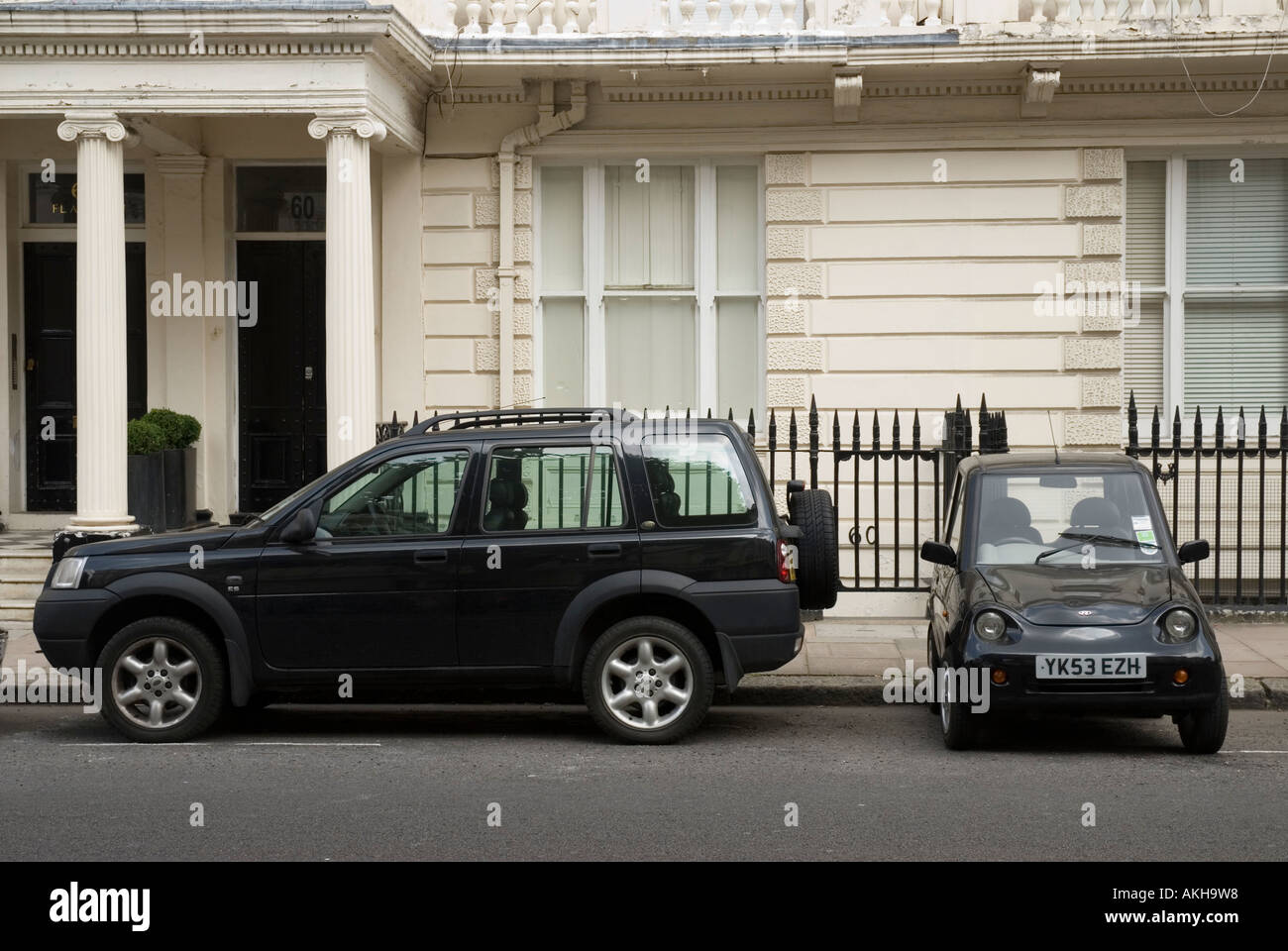 Reva G Wiz electric car parked next to a 4x4 on a London street in the UK Stock Photo
