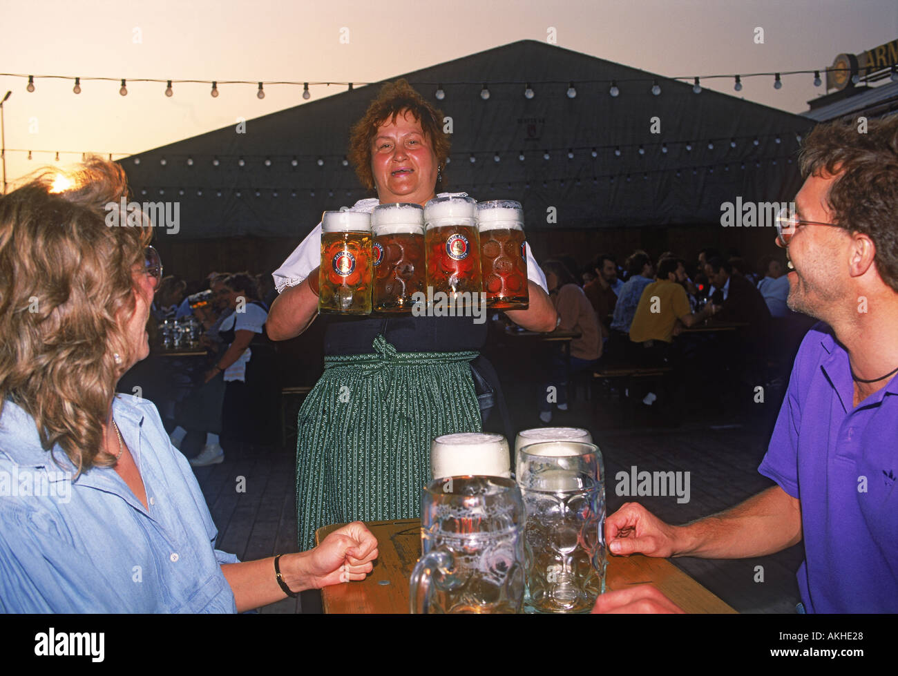 Waitress delivering steins of beer at Oktoberfest in Munich Stock Photo