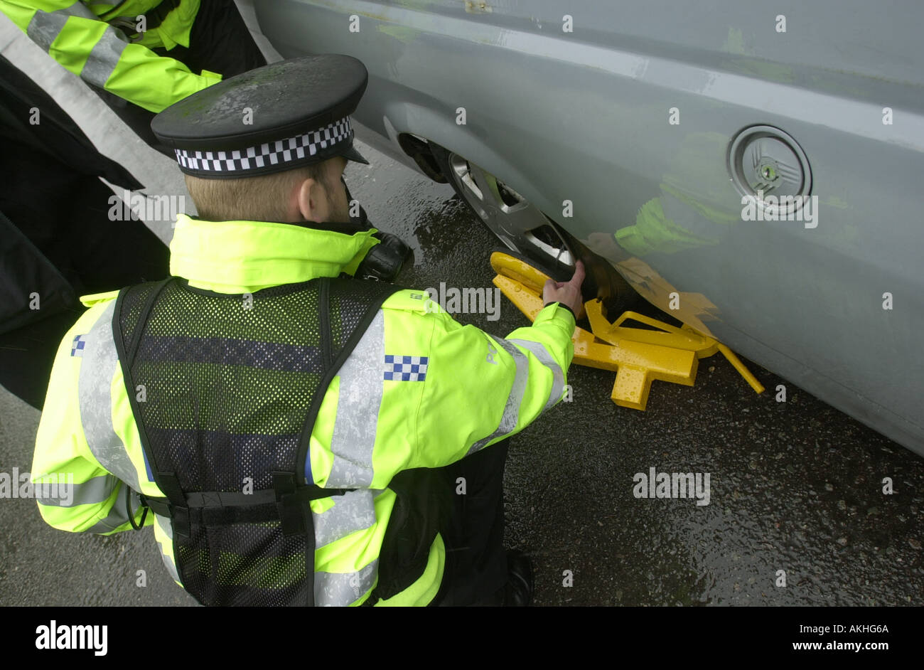 Police officer checks a clamp on an untaxed car which appears to have