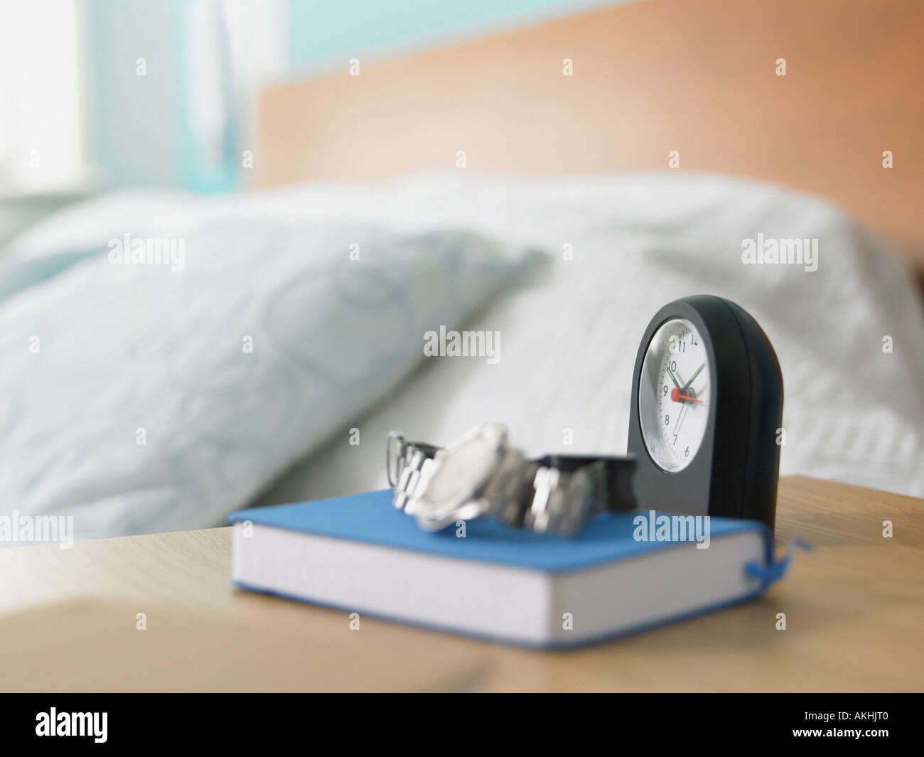 Clock and book on a bedside table Stock Photo