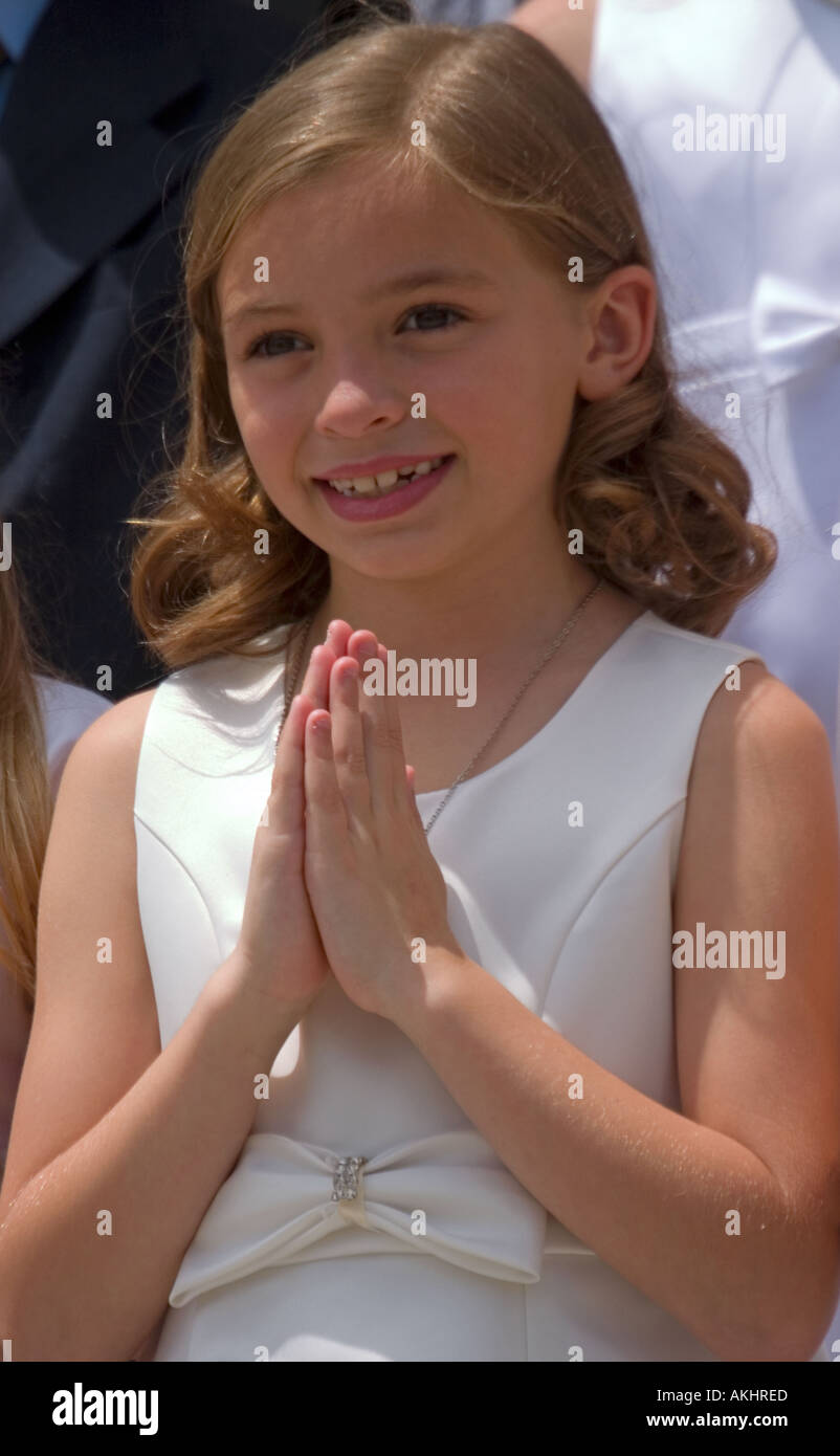 A pretty young girl smiles on the occasion of her first Holy Communion Stock Photo