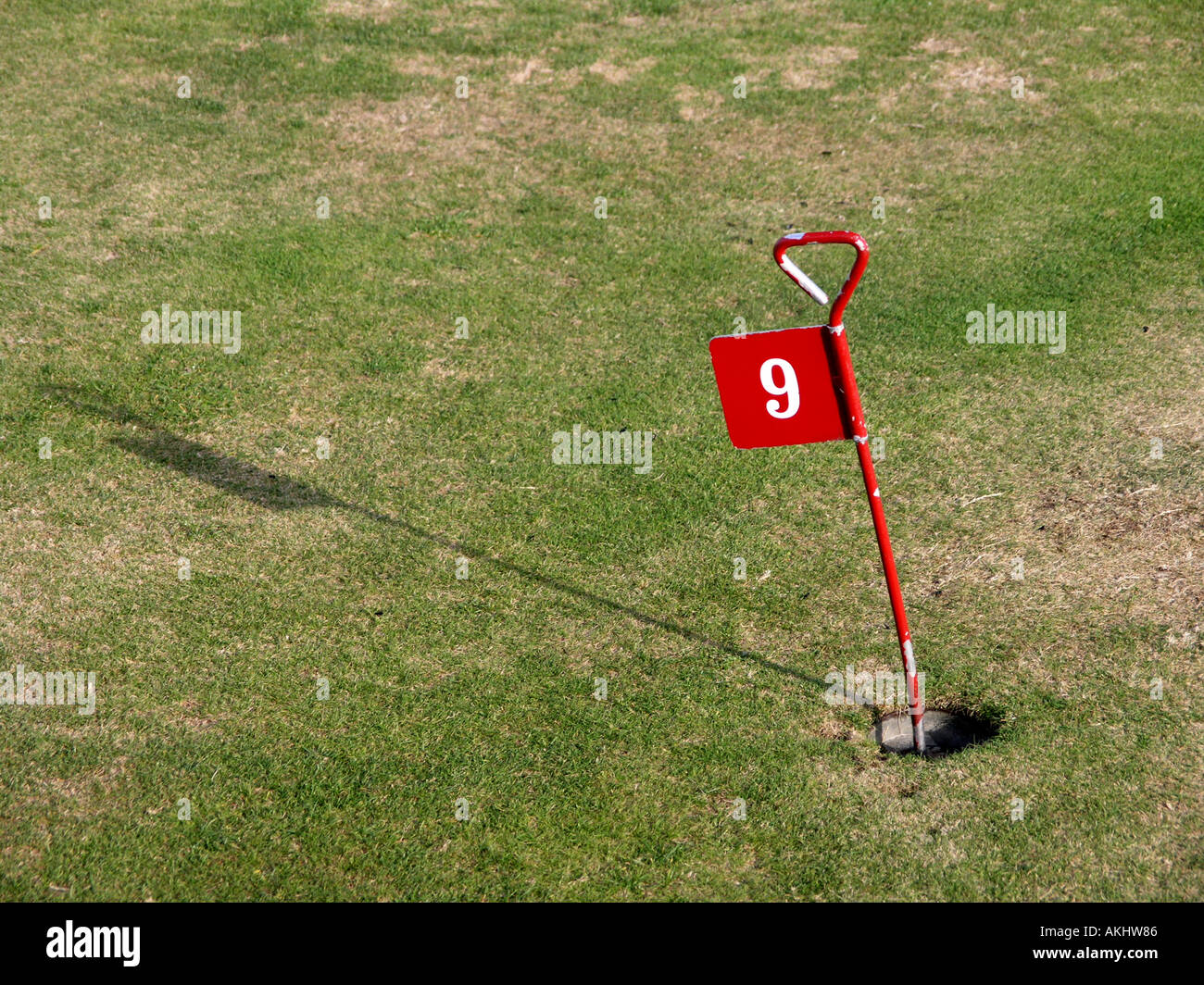 Putting Green hole number nine marked with red metal flag Stock Photo