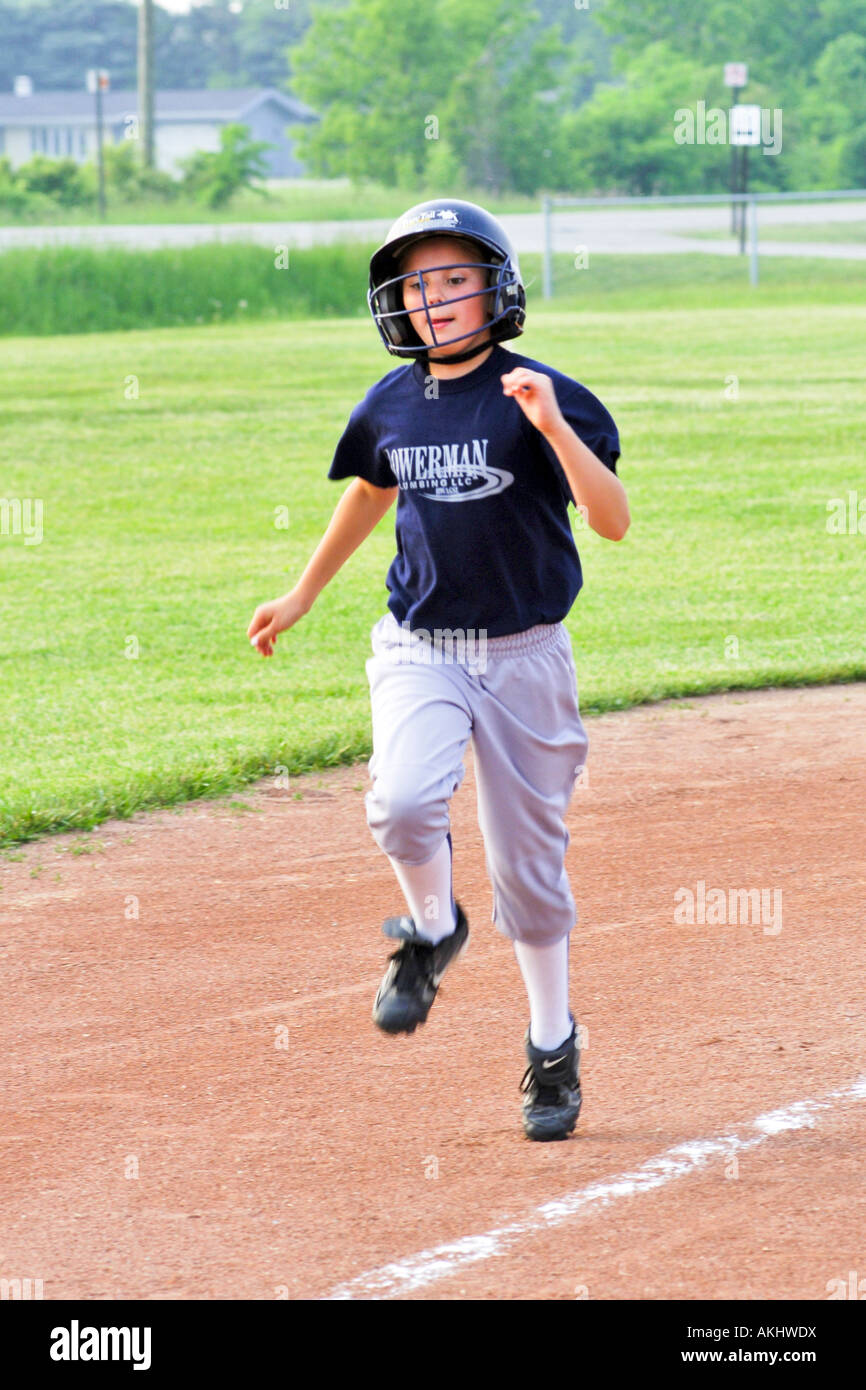 Female softball player waiting to run to third base wearing a black helmet Stock Photo Alamy