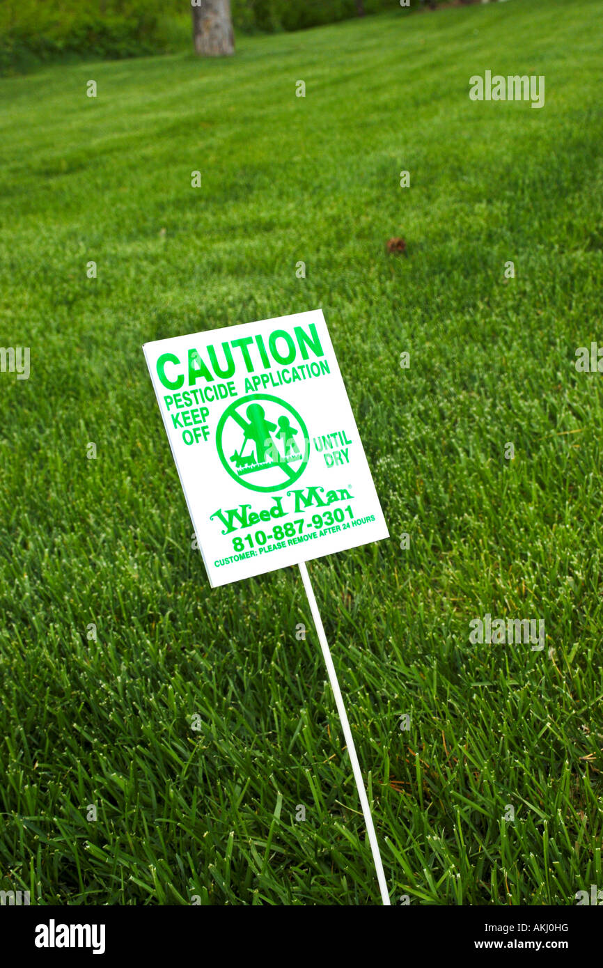 Caution sign on a lawn that has just been sprayed with pesticides Stock Photo