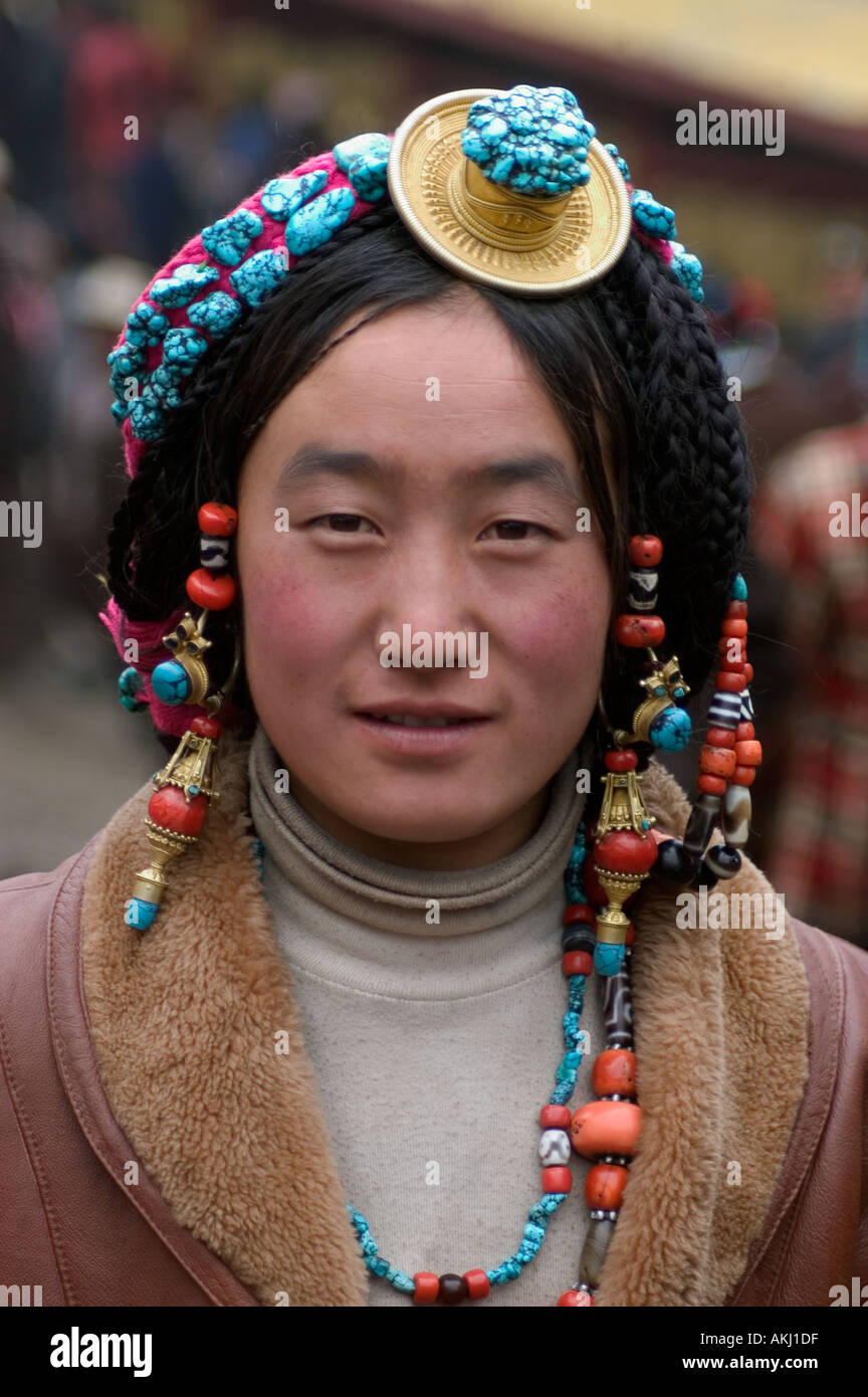 Khampa woman wears a gold and turquoise hair piece at the Monlam Chenpo Katok Monastery Kham Tibet Sichuan China Stock Photo