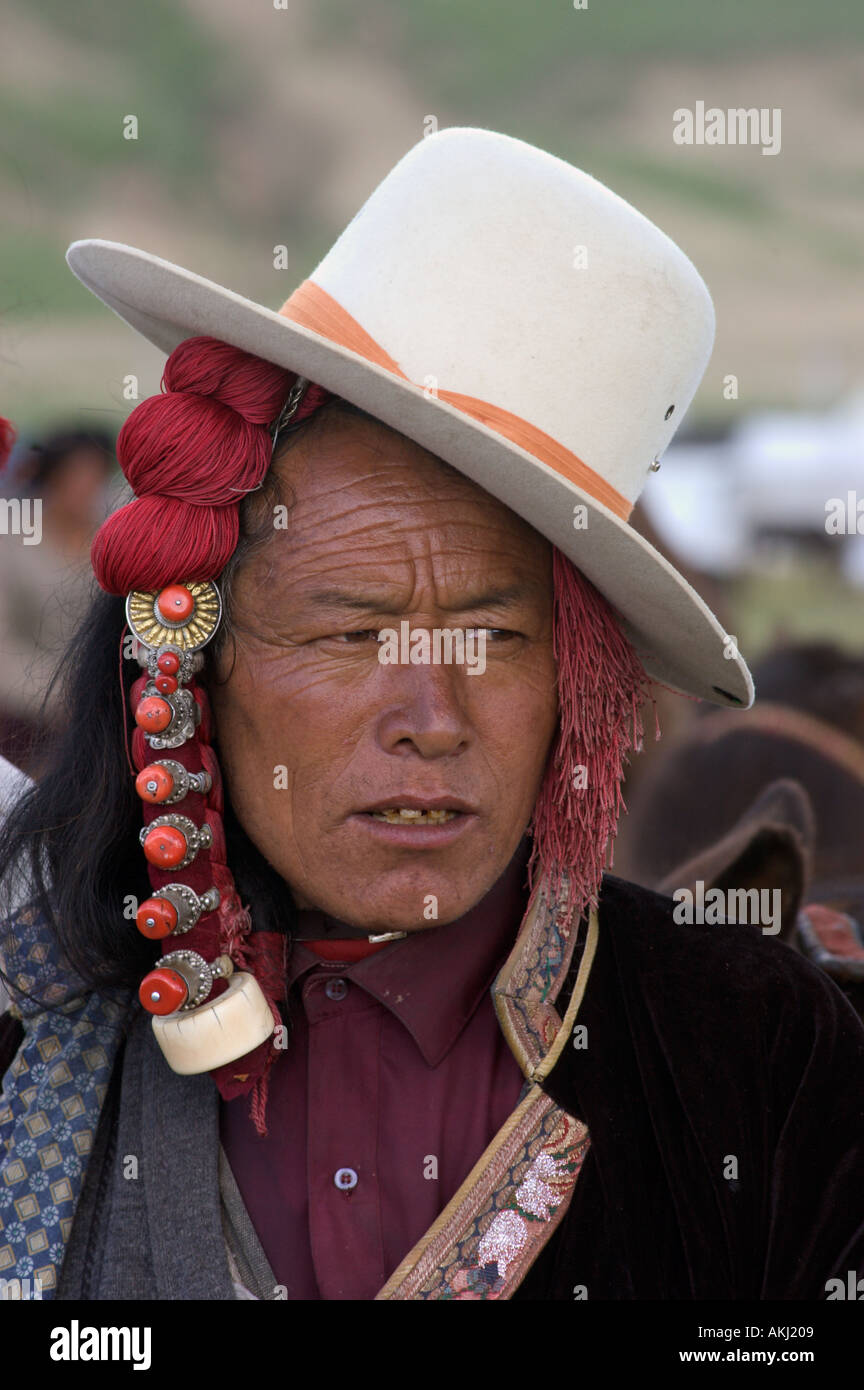 Khampa with jaunty cowboy hat and ivory hair peices at the Litang Horse Festival in Kham Sichuan Province China Tibet  Stock Photo