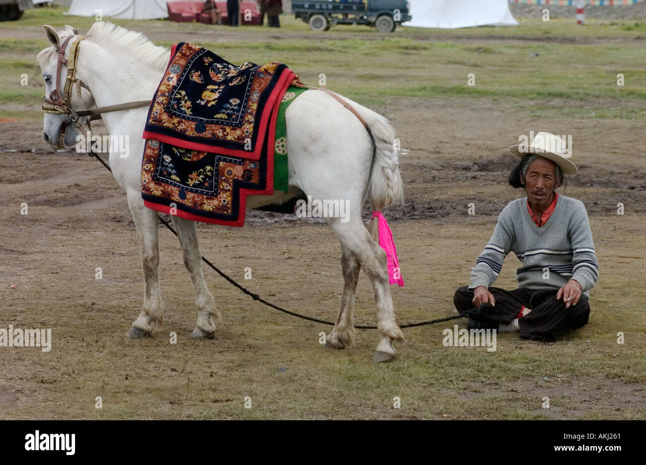 Khampa man Tibetan pony wait for a chance to race at the Litang Horse Festival Sichuan Province China Eastern Tibet  Stock Photo