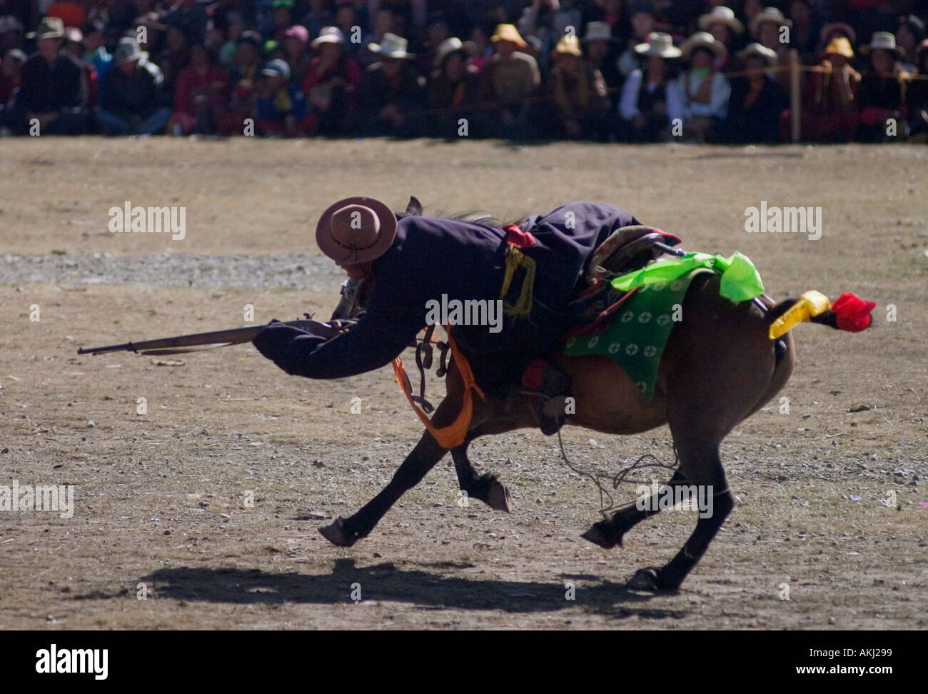 A Khampa competes in rifle shooting contest on horseback at the Litang Horse Festival in Kham Sichuan Province ChinaTibet Stock Photo