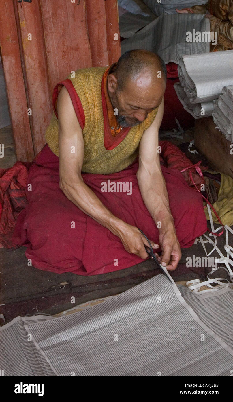 A Buddhist monk trims a sacred text at a monastery in Dabpa County Kham Sichuan Province China Tibet  Stock Photo